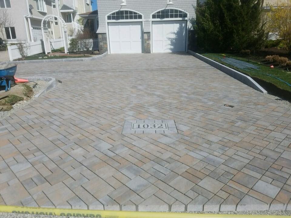 Paver driveway with inlaid house number and granite curbing
