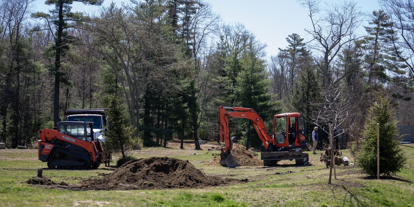 Excavator and track loader grading a site
