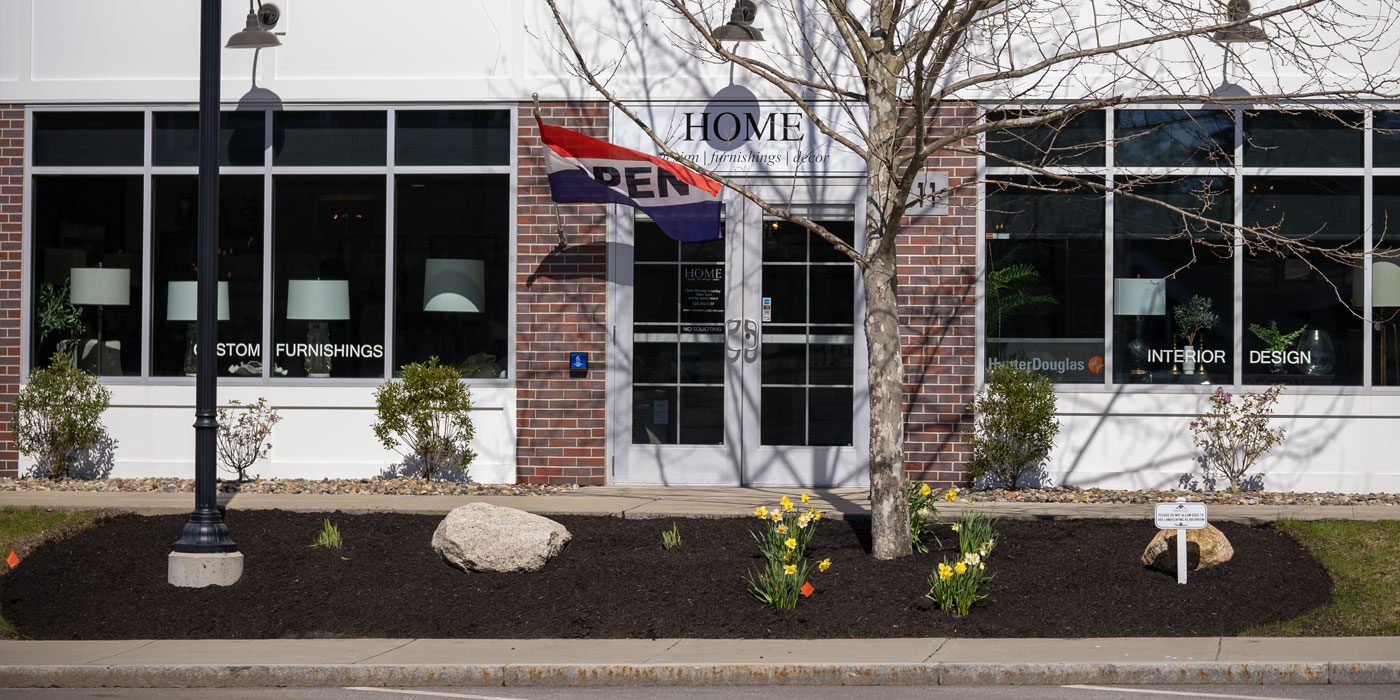 Commercial storefront bed with fresh mulch, boulder and daffodils