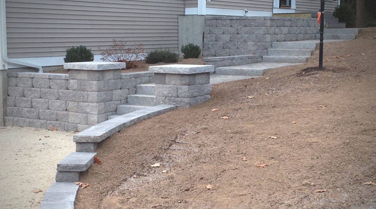 Block retaining wall with pillars and granite steps